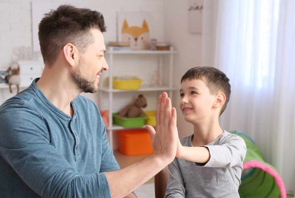Image of a father and son sitting together, discussing and implementing strategies to manage Pathological Demand Avoidance (PDA) behaviors.